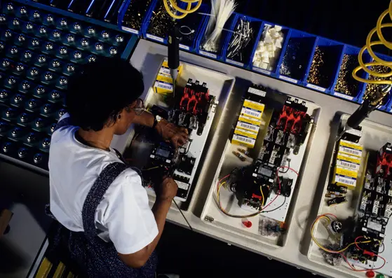 Technicienne effectuant le reconditionnement et les tests de composants d’ascenseur pour le catalogue TrackLift